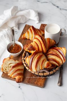 some food is laying out on a cutting board next to a cup and saucer