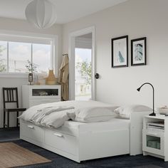 a white bed sitting in a bedroom next to a window