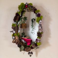 a mirror hanging on the wall covered in plants