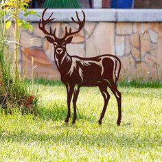 a metal deer statue standing in the grass