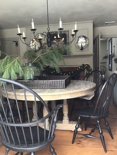 a dining room table with four chairs and a clock on the wall in the background