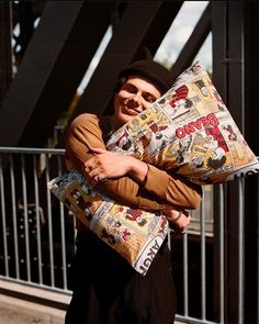 a man is holding a pillow with newspaper covers on it