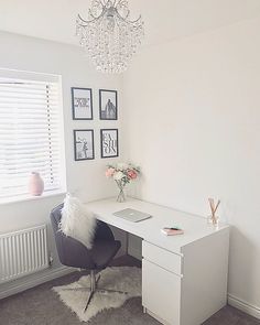 a white desk with a laptop computer on top of it in front of a window