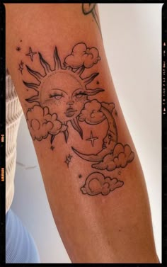 a sun and moon tattoo on the left arm, with clouds in the foreground