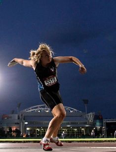 a woman running on a track at night