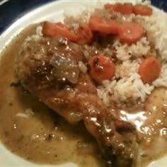 a white plate topped with meat and rice covered in gravy