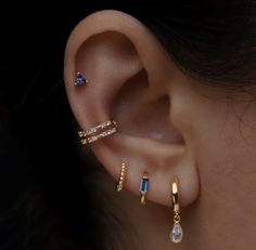 a woman's ear with three different types of piercings