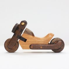 a wooden toy motorcycle with wheels on a white background