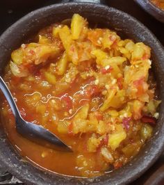 a bowl full of food with a spoon in it