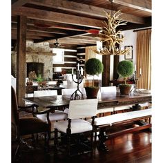 a dining room table with chairs and a chandelier hanging from the rafters