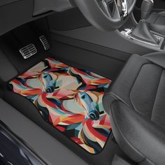 the interior of a car with a colorful horse design on it's floor mat