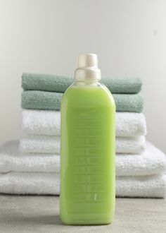 a bottle of green liquid sitting on top of towels