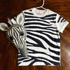 a zebra mask and t - shirt on a wooden table with a light bulb plugged in