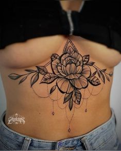 a woman's stomach with a flower tattoo on it