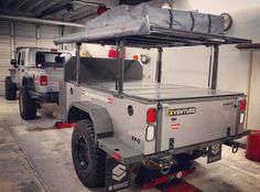 the truck is parked in the garage next to another truck with a tarp on top