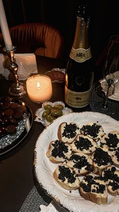 an assortment of appetizers are on a plate next to a bottle of wine