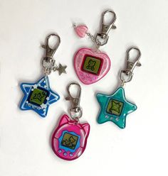 four keychains with different designs on them, one in the shape of a star