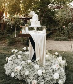 a wedding cake on top of a table surrounded by flowers