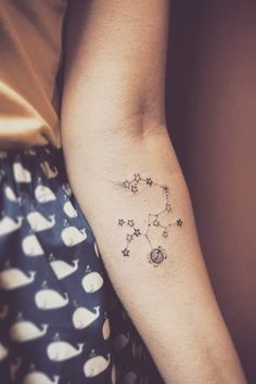 a woman's arm with stars and moon tattoos on the left side of her arm