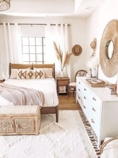 a bedroom with a bed, dresser and mirror on the wall next to a window