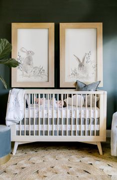 two framed pictures above a crib in a baby's room with white furniture