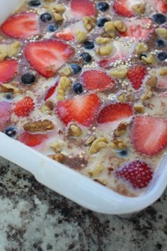 a white dish filled with fruit and nuts