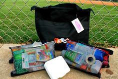 three bags sitting next to each other on top of a cement slab in front of a chain link fence