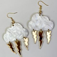 "Let every day be a rainy and stormy day with these storm cloud dangle earrings. Choose from white cloud, pink clouds, sparkle clouds, or smoke grey clouds. Silver, gold, or translucent lightning bolts. Drop length 3.5\" Length 2.34\" width 1.34 Jump rings and ear wires are nickel free." Cloud Fashion, Cloud Jewelry, Cloud Rain, Cloud Earrings, Cloud Pink, Lighting Bolt, Lightning Bolts, Grey Clouds, White Cloud