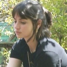 a young woman sitting on a bench looking at her cell phone