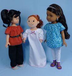 three dolls standing next to each other on a blue background