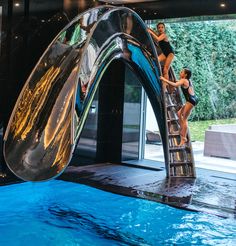 two girls are playing on a slide in the pool