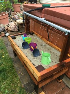 sandbox with buckets and cups in it