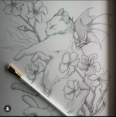 a drawing of a cat and flowers on a sheet of paper next to a pen