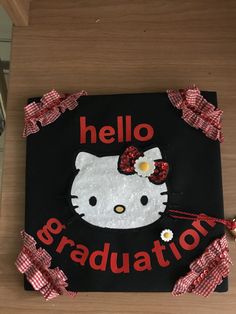 a hello kitty graduation sign on a table