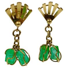 This is a stunning pair of Retro Emerald Dangle Drop Earrings with four chunky rough cut Emerald gems of great beauty set in an 18 Karat Gold wire wrap dangle design. The Emeralds hang from a fan shape surmount. The earrings have classic Retro Mid-Century Modern design. The emeralds are a wonderful vivid green which are full of natural garden inclusions and the natural crystalline forms of the gems. They dangle beautifully from the fan shaped surmount. The earrings have posts. Such beautiful and Emerald Gem, Retro Mid Century Modern, Natural Garden, Gold Wire, Beauty Sets, Rough Cut, Earrings Dangle, Wire Wrap, A Fan