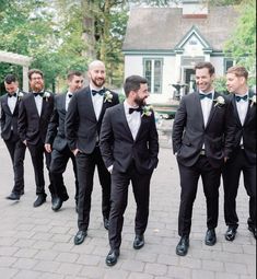 a group of men in tuxedos standing next to each other on a brick walkway