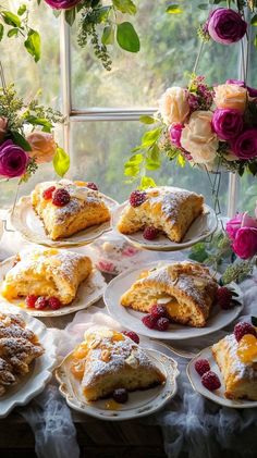 there are many desserts on the table with flowers in the window sill behind them