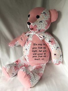 a pink teddy bear sitting on top of a white sheet with a poem written on it