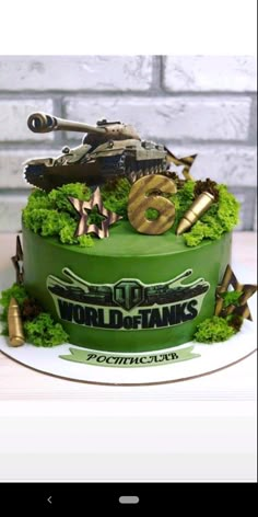 a cake decorated with green moss and tanks