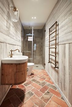 a bathroom with a toilet, sink and shower stall in it's center area