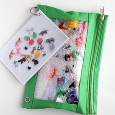 an open green bag with buttons and magnets on the inside, sitting on top of a white table