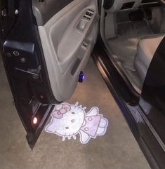 the interior of a car with hello kitty decal on the floor next to it