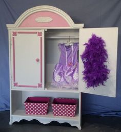 a doll's wardrobe with purple and white accessories on it, next to two baskets