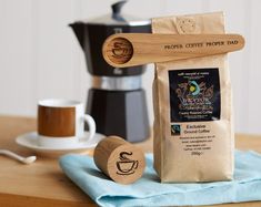 a coffee bag and wooden spoon sitting on top of a table