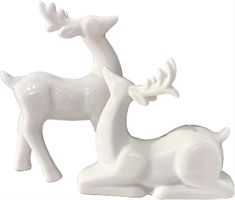 two white ceramic deer figurines sitting next to each other on a white background