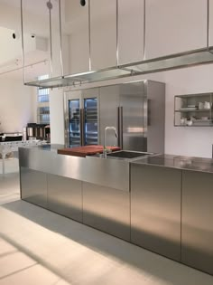 a kitchen with stainless steel counter tops and appliances on the wall behind it is an open area for cooking