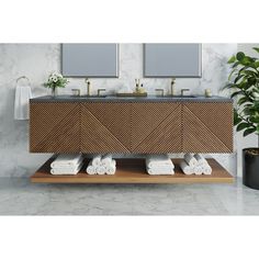 a bathroom vanity with two mirrors above it and towels hanging on the counter top next to it