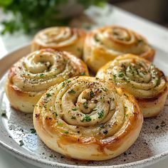 several rolls on a white plate with parsley sprinkled around the top and sides