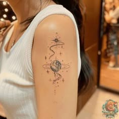 a woman with a tattoo on her arm that has an image of the planets and stars