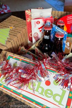 an open box filled with soda bottles and confetti on top of a table